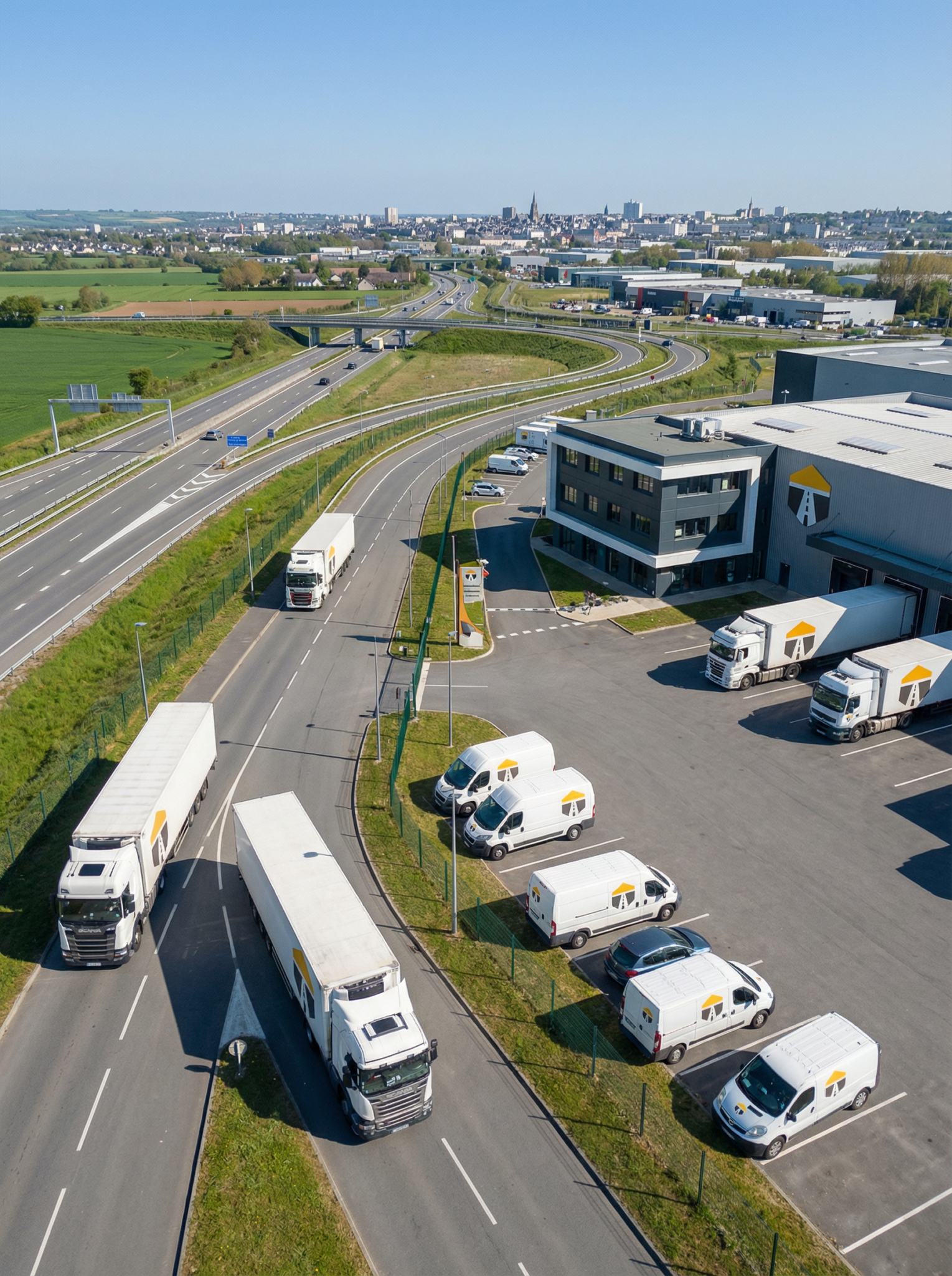 Camions et fourgonnettes devant un entrepôt logistique.